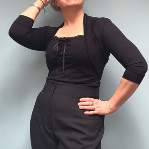 Bolero lightweight jacket, 3/4 sleeves, perfect over sleeveless dresses for arm coverage and shoulder  warmth. Colours come in black, white and navy, in sizes small, medium, large and Xlarge. Easily stored in a clutch bag, when not being worn.