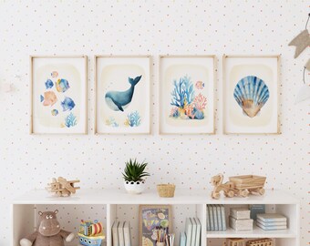 May include: Four framed watercolour prints depicting marine life. The prints show colourful fish, a whale, coral, and a seashell. The artwork is set against a cream background with a light wood frame. The wall has a polka dot pattern.