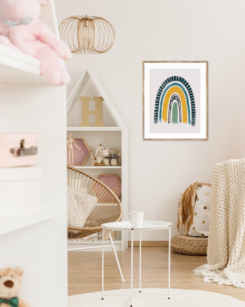 Puede incluir: Una impresi&oacute;n enmarcada de un arco&iacute;ris colorido con un esquema de colores amarillo, verde y azul. El arco&iacute;ris est&aacute; pintado en un estilo texturizado con puntos blancos. La impresi&oacute;n est&aacute; colgada en una pared blanca en una guarder&iacute;a.