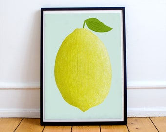 Puede incluir: Una impresión enmarcada de un solo limón amarillo con una hoja verde sobre un fondo azul claro.