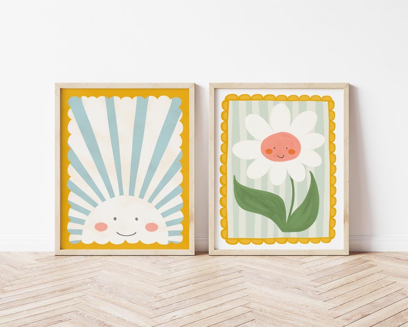 May include: Two framed prints with a yellow border. The print on the left features a blue and white striped sun with a smiling face. The print on the right features a white daisy with a smiling face and green leaves on a light green and white striped background.