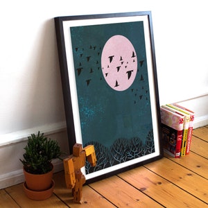 May include: A framed print of a teal blue background with a pink moon and black silhouettes of birds flying in the sky. The print is in a black frame.