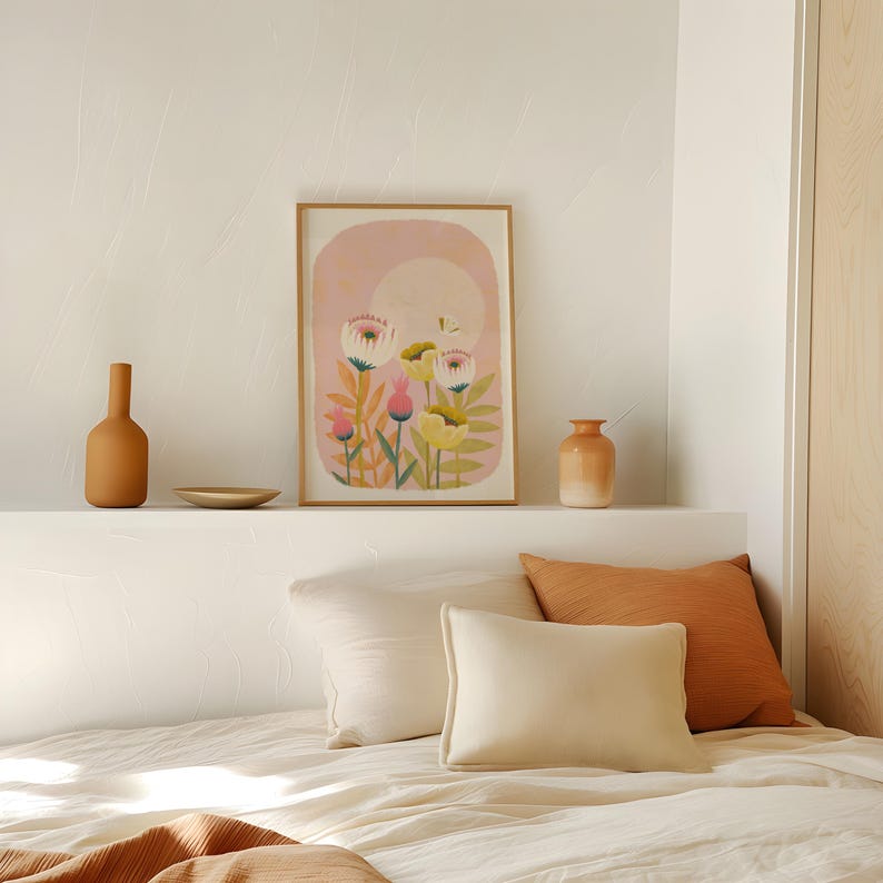 May include: A framed print of a floral illustration with pink, yellow, and white flowers on a pink background. The print is hanging on a white wall above a shelf with two brown ceramic vases.