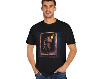 May include: Black t-shirt featuring a digital illustration of a figure holding a torch in a stone doorway. The artwork depicts a person in medieval attire, illuminated by the torch's flame. The shirt is made of a soft, comfortable material.