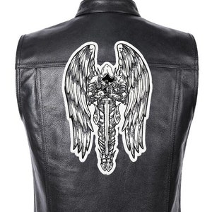 Può includere: Gilet di pelle nera con una toppa ricamata bianca di un angelo con le ali che tiene una spada.