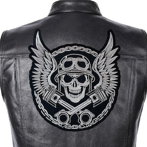 May include: A black and silver embroidered patch featuring a skull wearing a helmet with goggles, crossed pistons, and wings. The skull is surrounded by a chain link design.