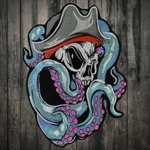 May include: An embroidered patch featuring a skull wearing a pirate hat, with a blue and pink octopus tentacle wrapped around it.