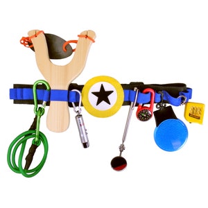 May include: A blue and black utility belt with a variety of tools and accessories attached, including a slingshot, a whistle, a compass, a mirror, a flashlight, and a green rope.