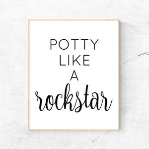 May include: White framed print with black text that reads "Potty Like A Rockstar".