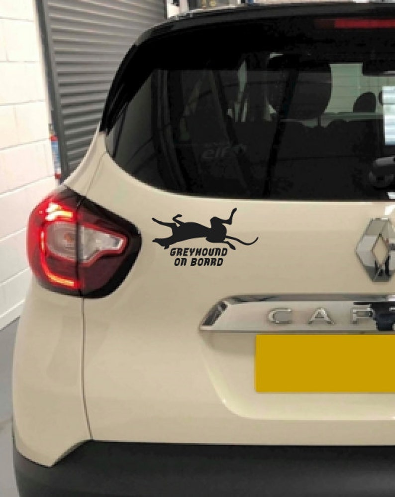 Peut inclure: Une voiture blanche avec une silhouette noire de l&eacute;vrier et le texte "Greyhound on Board" sur la vitre arri&egrave;re.