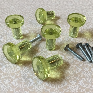 Puede incluir: Seis pomos de armario de vidrio amarillo-verdoso con herrajes de metal plateado y un conjunto de tornillos plateados. Los pomos tienen una forma redondeada, similar a un hongo, para un toque vintage.