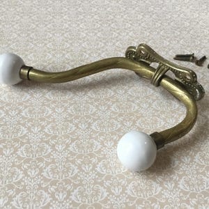 May include: White ceramic mug with a black handle, featuring the text "But First, Coffee" in black. The mug is displayed against a blurred backdrop, implying a comfortable environment.