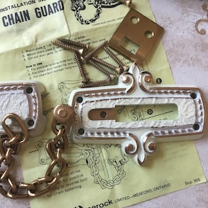 Puede incluir: Un juego de protector de cadena blanco y dorado con una guía de instalación y tornillos. El juego incluye una placa rectangular con una cadena, una placa cuadrada y una pequeña placa de metal. La guía de instalación es amarilla y tiene texto negro.