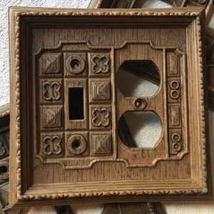 Peut inclure: Une plaque de recouvrement pour interrupteur et prise de courant en bois brun avec un design orné. La plaque de recouvrement est de forme carrée avec une bordure surélevée et une surface texturée.
