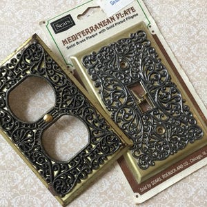 Puede incluir: Dos placas de pared vintage de latón macizo de estilo mediterráneo con filigrana chapada en oro. Una es para un enchufe, la otra para un interruptor de luz. Las placas de la marca Sears aún están en su embalaje original.
