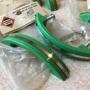 Peut inclure: Tirants de meubles verts et argentés avec un design incurvé. Les poignées ont une finition vert vif avec une bande argentée. Le matériel est neuf, avec l'emballage et les étiquettes d'origine de Winnipeg Supply.