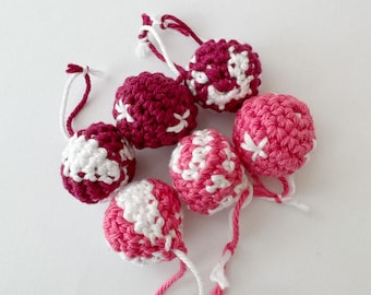 May include: Six crocheted ornaments in pink and white with a snowflake design. The ornaments are handmade and have a delicate, feminine look.