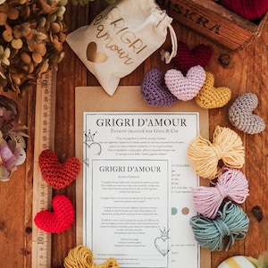 Puede incluir: Un kit de manualidades para hacer amuletos de corazón tejidos a crochet. El kit incluye hilo de varios colores, un patrón impreso y una pequeña bolsa con la inscripción "Grigri d'amour".