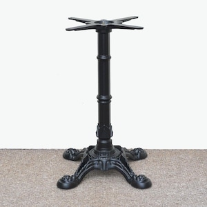 May include: Black cast iron table base with a four-pronged star-shaped top and three decorative legs.