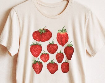 May include: A white t-shirt with a red strawberry print. The strawberries are arranged in a random pattern on the front of the shirt.
