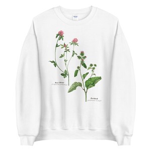 May include: White sweatshirt with a botanical illustration of red clover and burdock plants. The plants are labeled with their scientific names.
