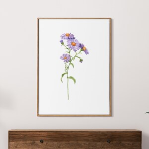 May include: A framed watercolor painting of a single stem of purple wildflowers with yellow centers. The flowers are in bloom and the stem is green. The background is white.