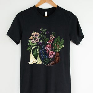 May include: Black t-shirt with a floral print featuring various flowers in shades of pink, purple, white, and green.