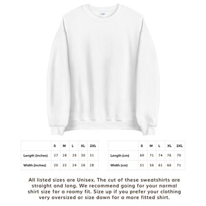 May include: Size chart for unisex sweatshirts in sizes S, M, L, XL, and 2XL. The chart shows measurements in inches and centimeters for length and width. The text below the chart states that the sweatshirts are straight and long, and recommends sizing up for a roomier fit or down for a more fitted shirt.