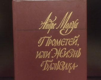 Könnte beinhalten: Ein burgunderfarbenes Hardcover-Buch mit goldenen Lettern auf dem vorderen Umschlag. Der Titel lautet "Prometey, ili Jeizn Bal'zaka" von Andre Morua.