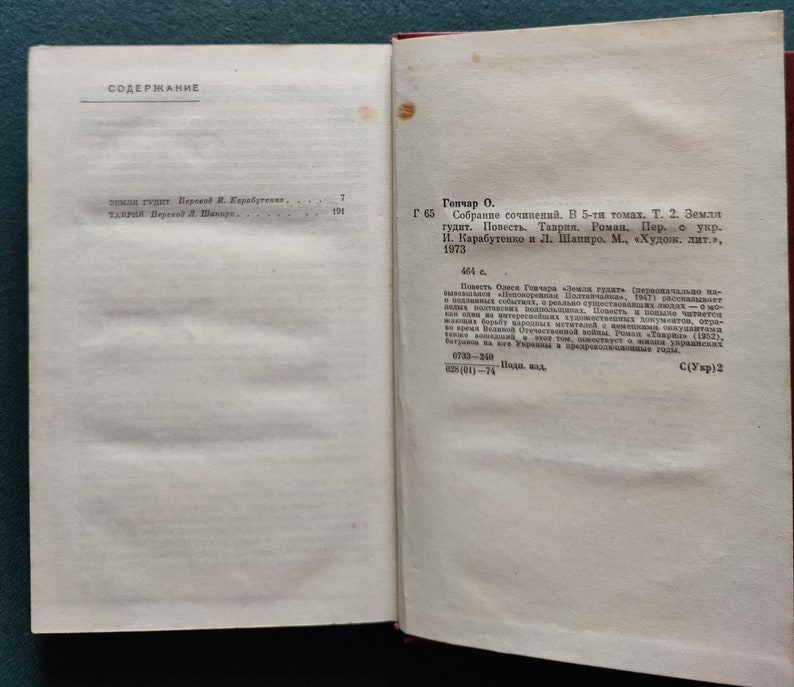 Puede incluir: Una p&aacute;gina de un libro con el t&iacute;tulo "Содержание" en la parte superior de la p&aacute;gina. La p&aacute;gina enumera el contenido del libro, incluido el t&iacute;tulo "Земля гудит" del autor О. Гончар. El libro fue publicado en 1973 por "Худож. лит.".