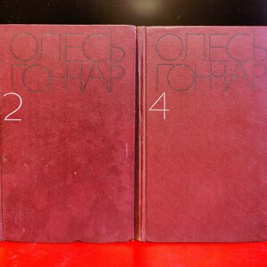 Puede incluir: Dos libros encuadernados en color burdeos con el texto "ОЛЕСЬ ГОНЧАР" y los n&uacute;meros "2" y "4" en los lomos.