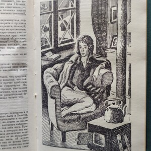 May include: A black and white illustration of a person sitting in a chair with a kettle on a table next to them. The person is looking down and has short hair. The chair is a large armchair with a high back. The kettle is on a small table with a small stove underneath it. The room is sparsely furnished and has a window in the background.