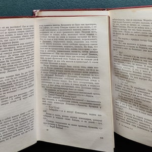 Puede incluir: Un libro abierto con p&aacute;ginas amarillentas y una cubierta roja. El libro est&aacute; abierto en una p&aacute;gina con texto en ruso. El texto trata sobre un grupo de personas que est&aacute;n de viaje. El libro est&aacute; sobre una mesa.