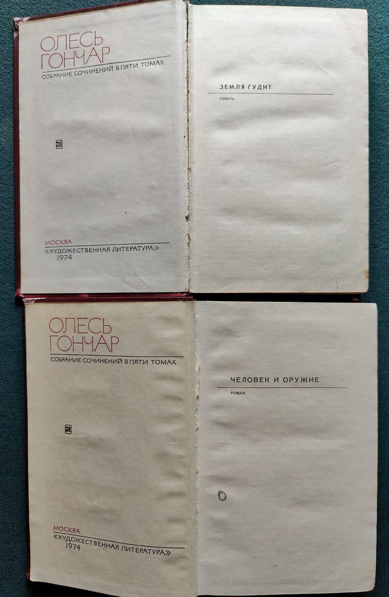 Puede incluir: Dos portadas de libros de una colecci&oacute;n de cinco vol&uacute;menes de las obras de Oles Honchar. La primera portada presenta el t&iacute;tulo "Zemlya Gudit" (La tierra ruge) y la segunda portada presenta el t&iacute;tulo "Chelovek i Oruzhiye" (El hombre y el arma).