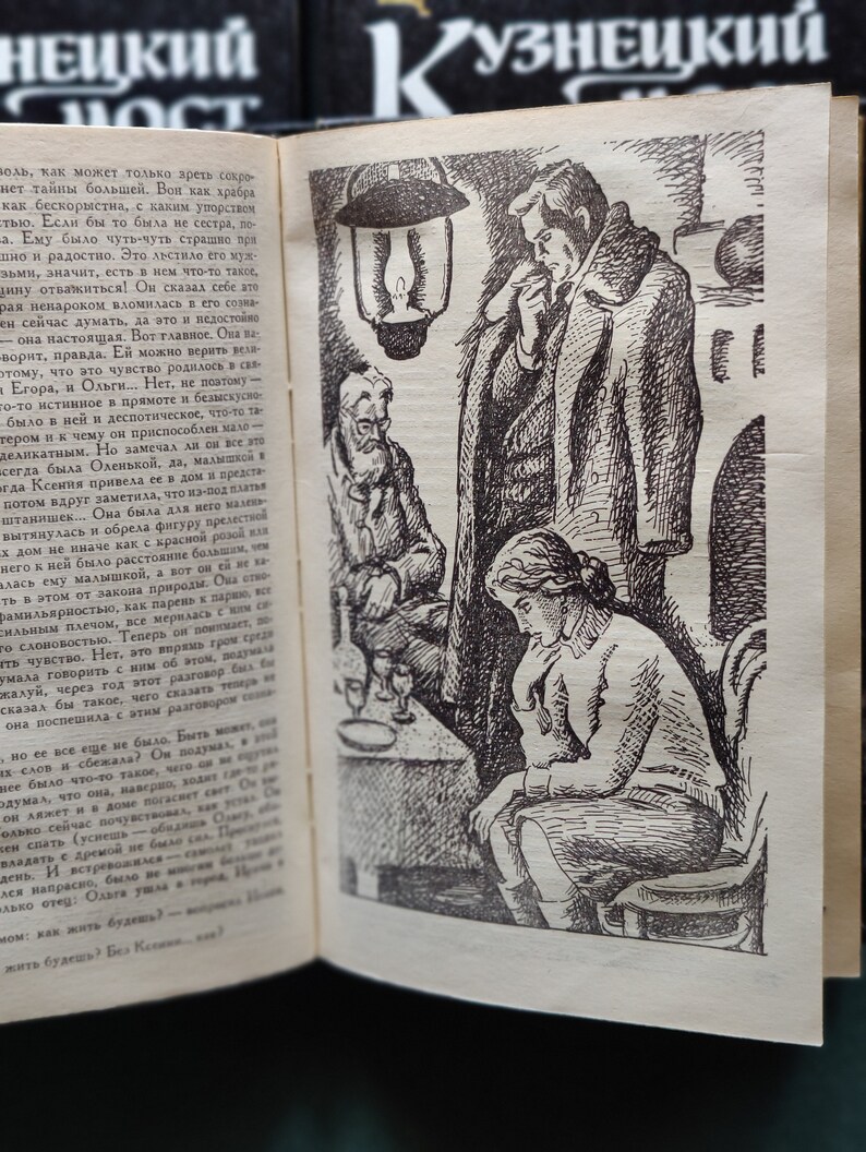 May include: A black and white illustration of three people sitting at a table. The people are drawn in a realistic style. The person on the left is a man with a beard and mustache. The person in the middle is a man with a mustache and a hat. The person on the right is a woman with long hair. The table is covered with a white tablecloth. There is a lamp hanging from the ceiling above the table. The illustration is from a book.