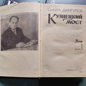 May include: A book cover with a black and white photo of a man in a suit. The book title is 'Кузнецкий Мост' in Russian. The author is 'Савва Дангулов' in Russian. The book is a novel and is the first book in a series. The book was published in Moscow by 'Советский Писатель' in 1980.