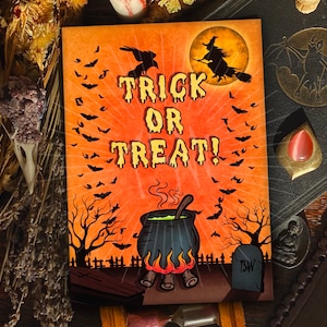 May include: A Halloween-themed card with an orange background and a cauldron with green liquid. The card says "Trick or Treat!" in a stylized font. There are bats flying around the cauldron and a witch flying on a broomstick in the upper right corner.