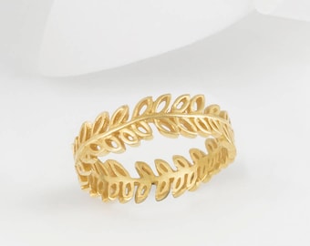 May include: A gold ring with a delicate leaf design. The ring is made of a single band with a repeating pattern of leaves.