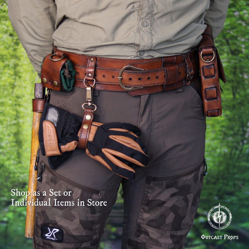 May include: A brown leather utility belt featuring a metal buckle, a small green pouch, a metal clip holding a black and tan glove, and a side holster. A wooden tool handle is visible on the left side. Text reads: Shop as a Set or Individual Items in Store.