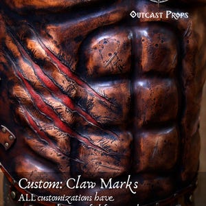 Front view of a Roman leather musculata cuirass, handcrafted with brown aged leather and metallic rivets.  Custom claw marks. The armor features sculpted abdominal muscles and distressed textures for a realistic battle-worn look. Ideal for Roman gladiator cosplay, LARP armor, or historical reenactment costume. Made from eco-tanned full-grain leather with epic weathering techniques.