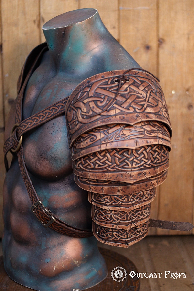Side view of Sedrik Viking leather shoulder armor, highlighting engraved Celtic knots on overlapping brown leather plates. Armor worn on a muscular mannequin torso, with adjustable leather straps crossing the chest, metal ring centerpiece, and a wooden background. Perfect for Viking cosplay, Celtic LARP costume, Norse warrior outfit, fantasy roleplay armor, medieval festival gear, premium handcrafted leather pauldrons with cinematic weathering effects.