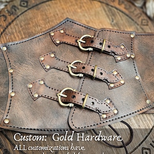 Aged brown leather underbust corset with custom golden brass hardware, handcrafted by Outcast Props. This witch corset features three buckle straps and decorative rivets, ideal for steampunk waist cincher, ren faire costume, and gothic festival outfit. Made from premium vegetable-tanned leather with artisan aging techniques, available upon request as a customization option for fantasy or LARP corsets.