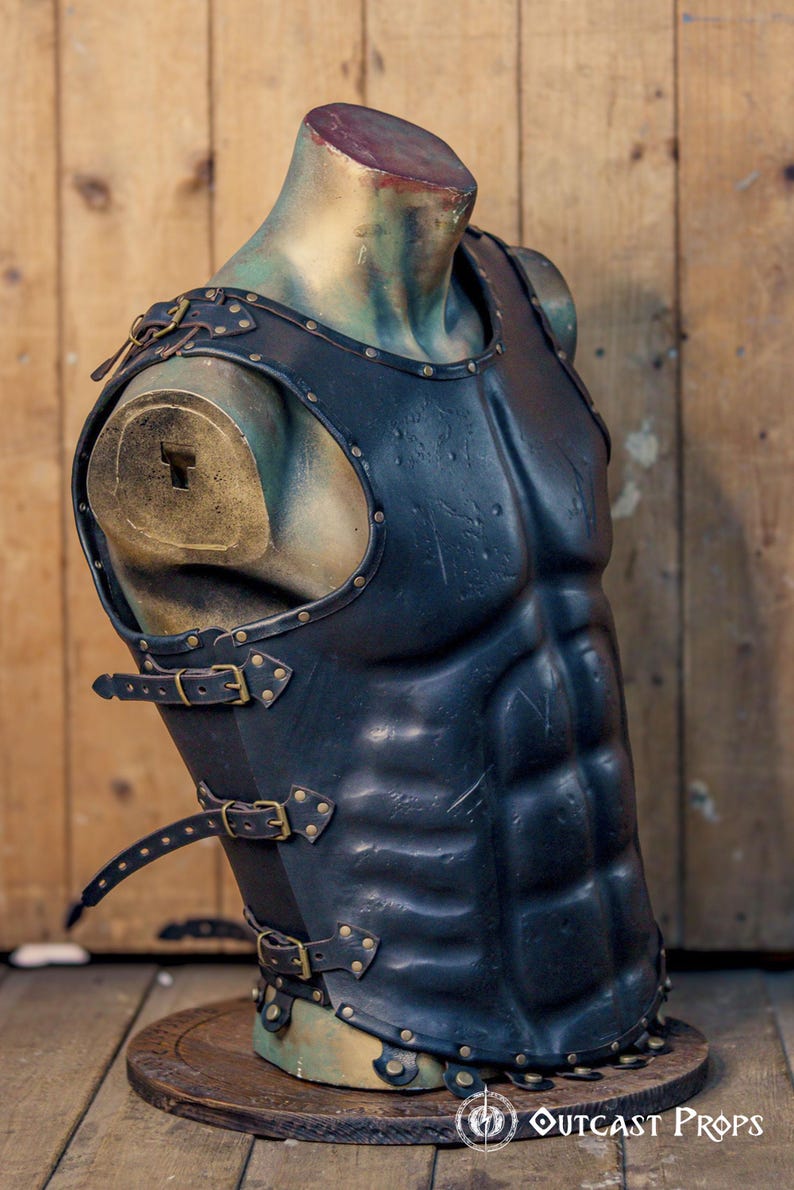 Side view of black leather Roman musculata cuirass with antique brass buckles and reinforced rivets, designed for LARP, Roman cosplay, or fantasy warriors. The sculpted abs and historical fit evoke the classical Greek ideal. Leather textures and shaped contours make the armor accessible to visually impaired users by enhancing tactile detail. Handmade and dyed with eco-friendly methods.
