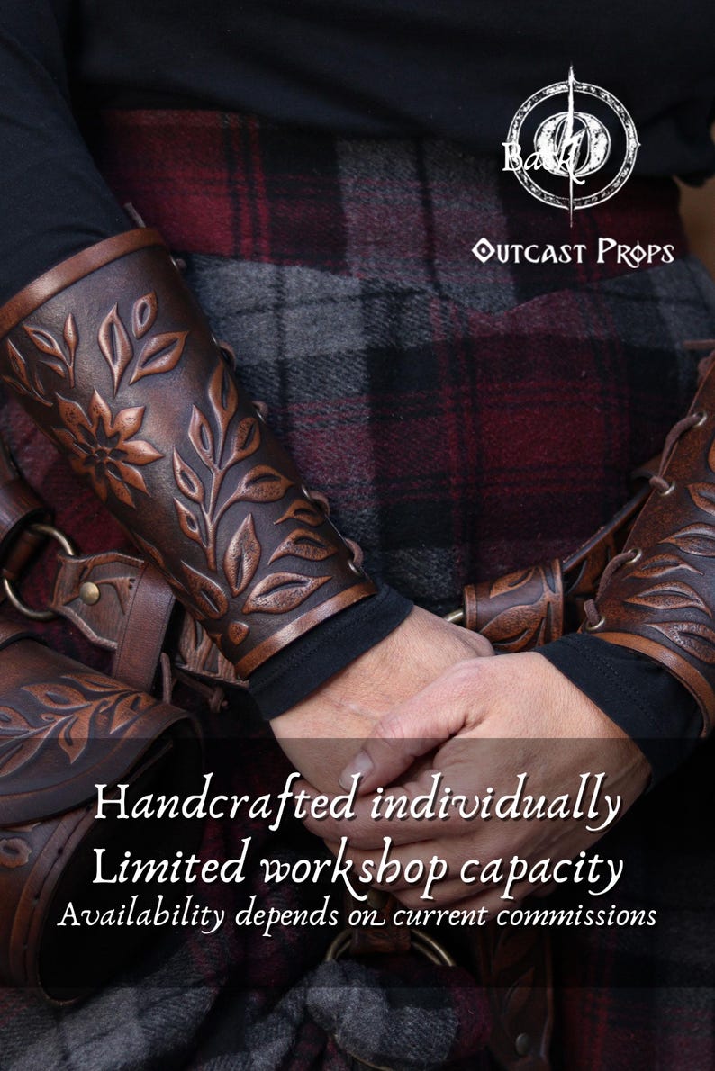 Two aged brown floral leather bracers are worn on crossed arms above a richly textured renaissance faire belt with a matching embossed pouch. The floral arm guard design features carved leaves and petals with deep highlights that emphasize the artisan finish. This larp bracer set fits naturally into medieval styled clothing, offering a fantasy cosplay accessory suitable for druids, elves or ranger characters. Warm browns and soft lighting enhance the handcrafted detail. Fae druid