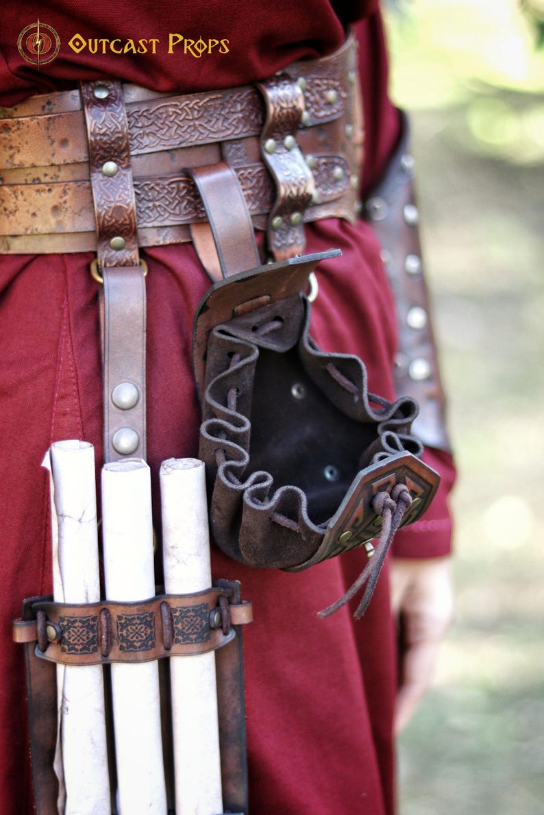 Open leather coin pouch hanging from a belt, showing the interior capacity. Small handcrafted pouch made from vegetable-tanned leather with embossed Celtic-style patterns and suede lining. Ideal for carrying coins, dice for tabletop games, or small daily items. A versatile leather accessory for Viking, Celtic, medieval, or dwarven aesthetics, suitable for LARP, cosplay, Renaissance fairs, or fantasy events. Leather coin pouch with Celtic or Viking embossing