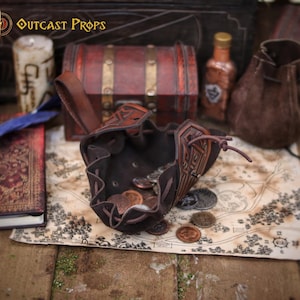 Open medieval leather coin pouch showing a soft suede interior filled with metal coins. Handmade from vegetable tanned leather with aged finish and embossed details. Compact belt pouch for coins, dice, keys, small valuables, or tobacco. Perfect for Viking, Celtic, dwarf aesthetics, fantasy costumes, LARP events, Renaissance fairs, and cosplay, combining practical carry with handcrafted character.
