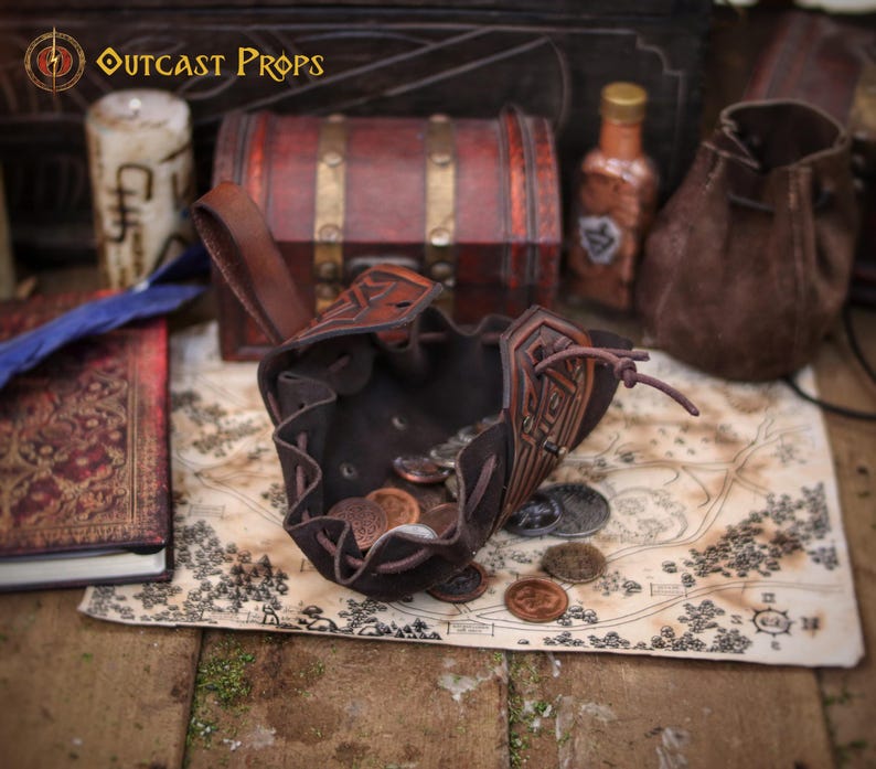 Open medieval leather coin pouch showing a soft suede interior filled with metal coins. Handmade from vegetable tanned leather with aged finish and embossed details. Compact belt pouch for coins, dice, keys, small valuables, or tobacco. Perfect for Viking, Celtic, dwarf aesthetics, fantasy costumes, LARP events, Renaissance fairs, and cosplay, combining practical carry with handcrafted character.