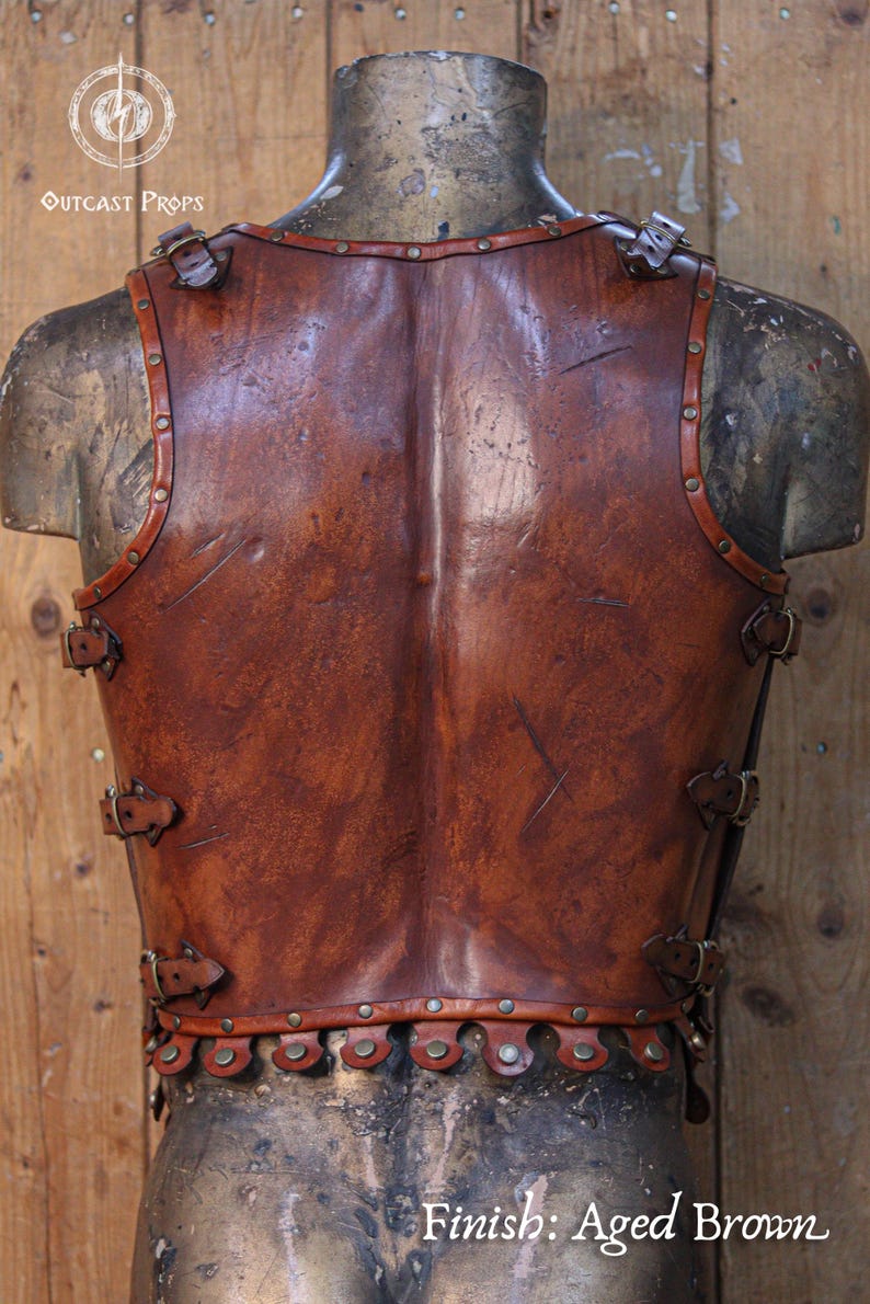 Close-up leather Roman gladiator armor, displaying detailed muscle shaping and battle scratches. This musculata cuirass is ideal for LARP events, cosplay warriors, and reenactment fans. Made with vegetable-tanned leather and hand-riveted accents, it mimics the heroic physique of Roman generals and fantasy heroes with striking realism.