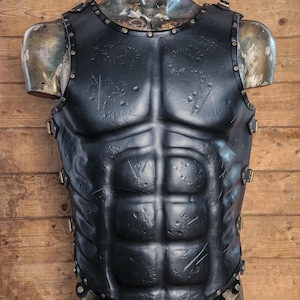 Front view of Roman leather musculata armor with visible abdominal definition, black leather surface and studded hemline. Ideal for Spartacus cosplay, Roman general costumes and medieval LARP. The muscle shaping and textured finish aid accessibility for low-vision users. Crafted with vegetable-tanned leather and hand-aged for a realistic, battle-worn look straight from history.