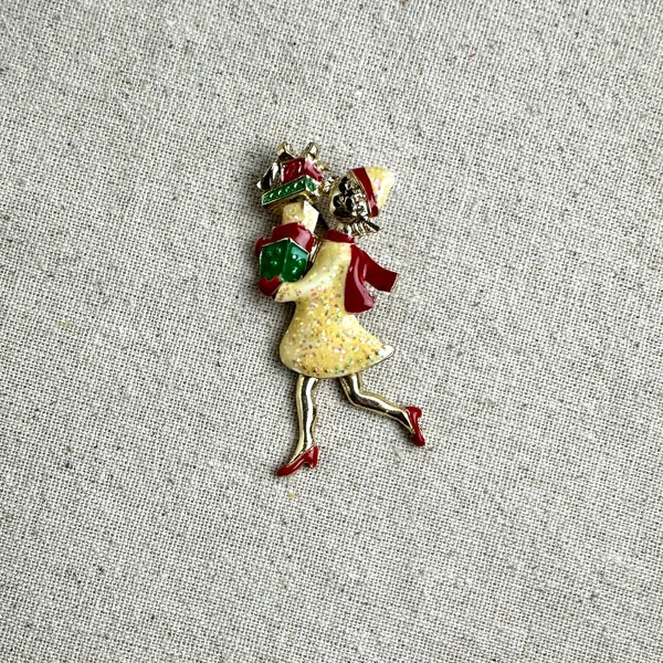 TC Holiday Brooch with Moveable Legs, 2 1/2" x 1", gold tone base metal, glittery finish, woman shopping theme, vintage, signed